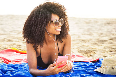 Beautiful young woman lying on beach