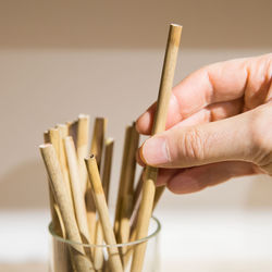 Close-up of hand holding wooden straw