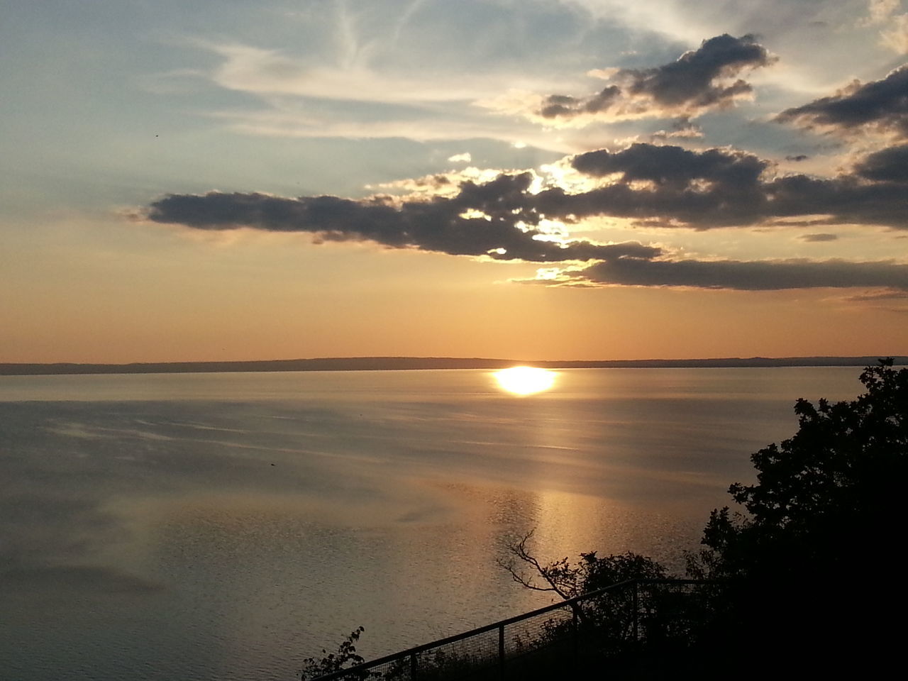 sunset, sun, tranquil scene, scenics, water, tranquility, beauty in nature, sky, reflection, sea, idyllic, nature, sunlight, cloud - sky, silhouette, sunbeam, horizon over water, tree, orange color, lake