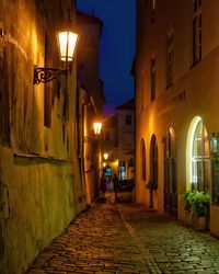 Narrow alley along buildings at night