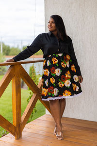 Young woman standing against wall