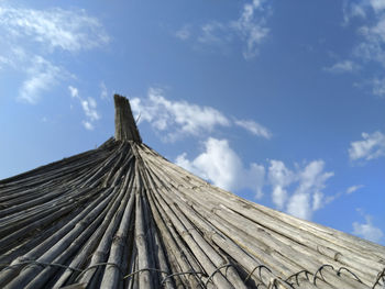 Low angle view of roof of building against cloudy sky