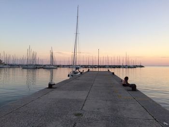 Pier on sea against sky during sunset