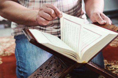 Midsection of man holding book