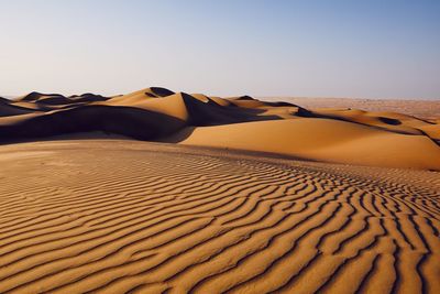 Scenic view of desert against clear sky during sunny day