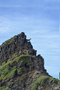 Low angle view of rock formation in sea against sky