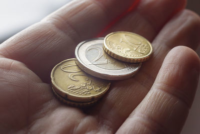 Close-up of hand holding coins