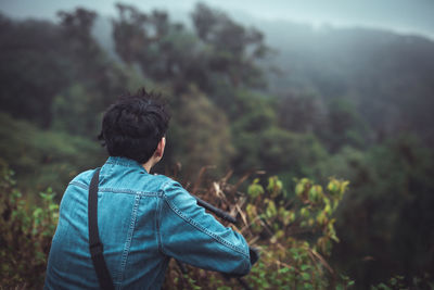 Rear view of man standing in forest