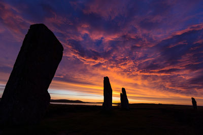 Silhouette stone posts  against sky during sunset