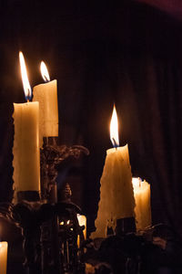 Close-up of burning candles in darkroom