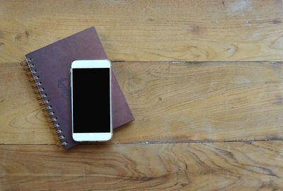 Directly above shot of smart phone diary on wooden table
