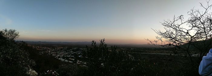 Scenic view of landscape against clear sky at sunset