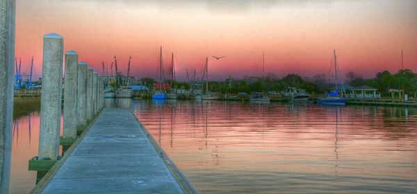 Boats in harbor at sunset