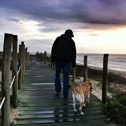 Pier on sea against cloudy sky