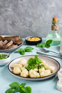 Potato gnocchi with pesto sauce on a plate on the table. italian traditional cuisine. vertical view