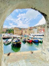 Boats moored in sea by buildings in city against sky