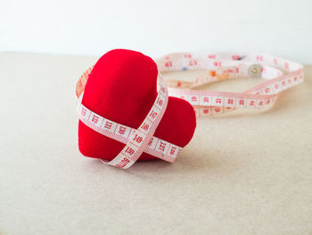 Close-up of heart shape on table against white background