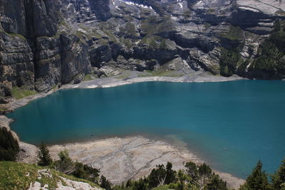 Scenic view of blue/turquoise alpine lake and mountains against sky