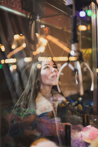 Portrait of smiling young woman at night