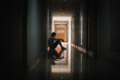 Side view of man standing in corridor of building