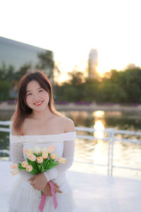 Portrait of smiling young woman with bouquet