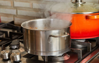 Pots with steam boiling on gas stove in the kitchen