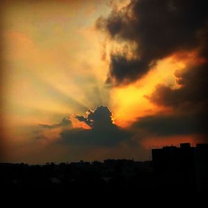Low angle view of silhouette buildings against dramatic sky