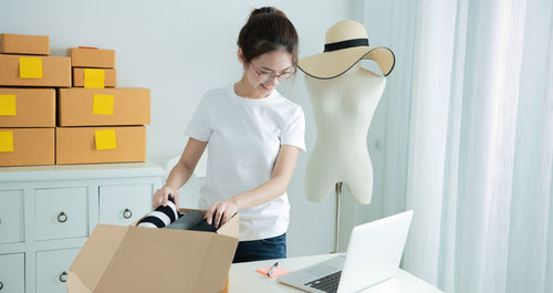 Side view of woman using laptop while sitting on table