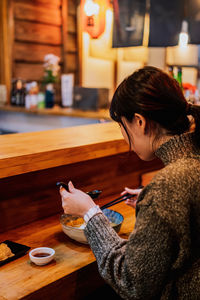 Woman holding coffee cup and table in cafe