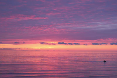 Scenic view of sea against romantic sky at sunset