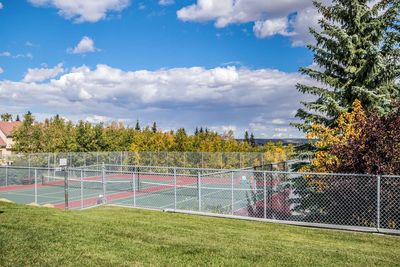 Scenic view of tennis court against cloudy sky.