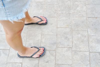 Low section of woman standing on tiled floor