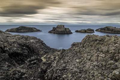 Scenic view of rocks in sea against sky