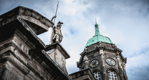Low angle view of clock tower amidst buildings against sky