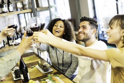 Happy friends toasting wine at restaurant