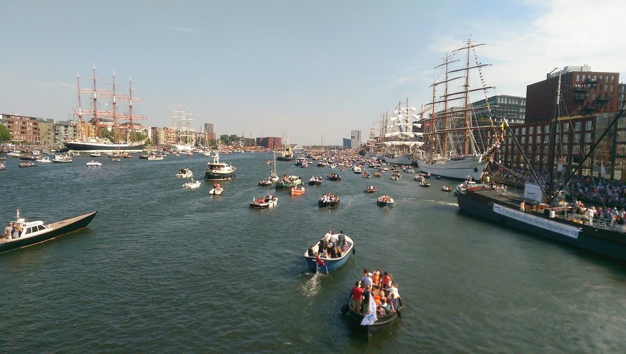 nautical vessel, transportation, mode of transport, boat, water, moored, waterfront, sea, harbor, mast, building exterior, sky, built structure, sailboat, architecture, travel, river, city, sailing, outdoors