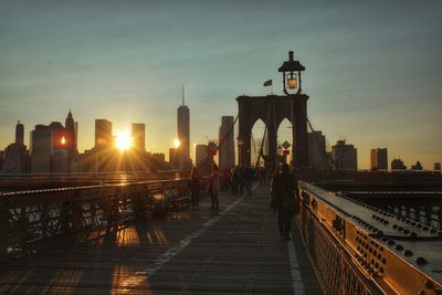 Brooklyn bridge with city in background during sunset