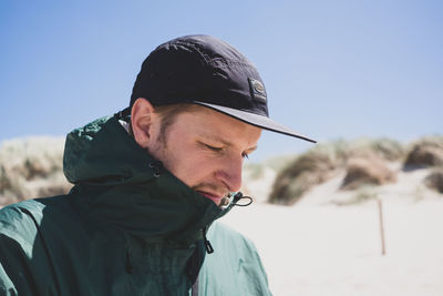 Portrait of young man standing against sky