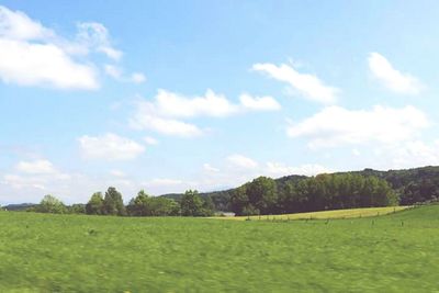 Scenic view of green landscape against sky