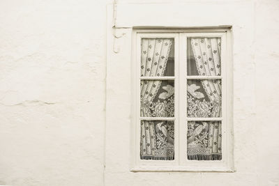 Closed window on white wall of building