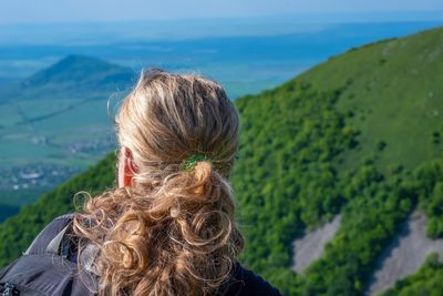 Rear view of woman looking at mountains against sky