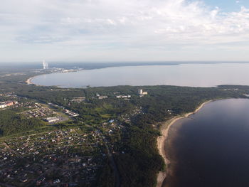 High angle view of city by sea against sky