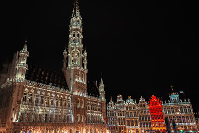 Low angle view of illuminated building against sky at night