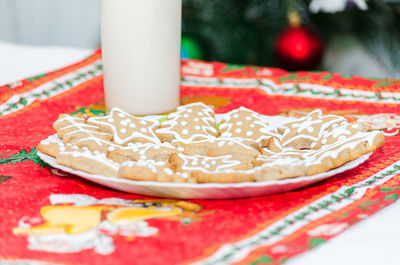 Close-up of gingerbread cookies by drink on table during christmas
