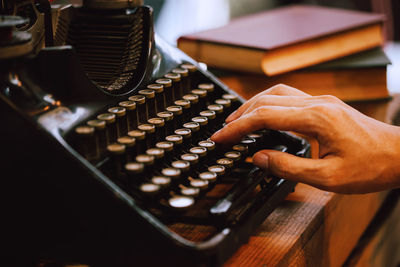 Cropped hand of man using typewriter