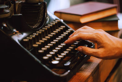Cropped hand of man using typewriter