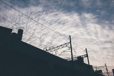 Low angle view of silhouette railway bridge against sky