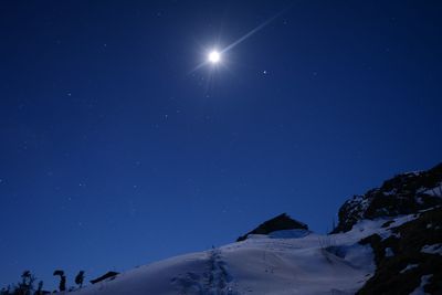 Low angle view of snowcapped mountain against sky at night