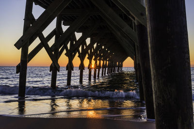 Bridge over sea against sky during sunset