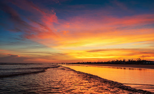 Scenic view of sea against dramatic sky during sunset